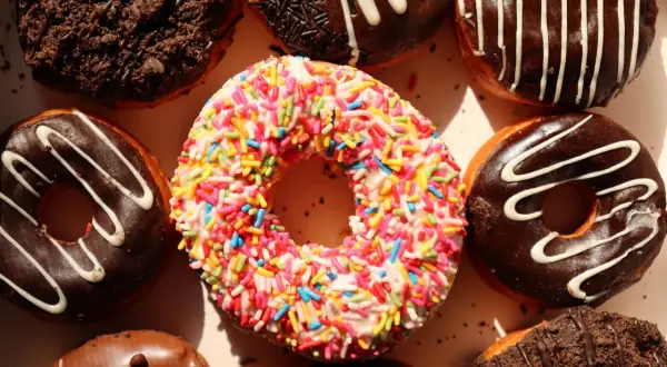 Kolorowe pączki z posypką i czekoladowe z polewą, idealne na cheat day.