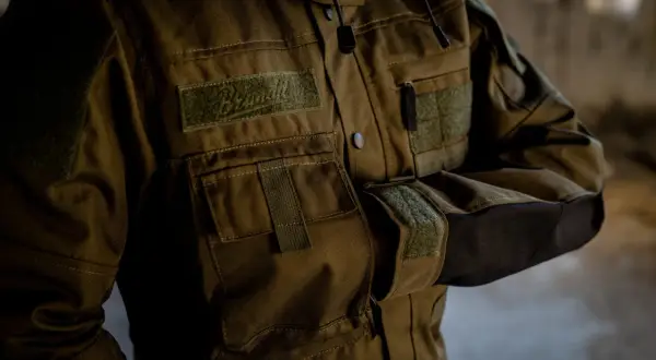 Kurtka z wytrzymałego materiału cordura, z licznymi kieszeniami i naszywkami. Idealna na wyprawy.