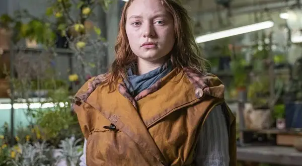 Mia Threapleton, con su mirada seria, posa en un invernadero lleno de plantas.