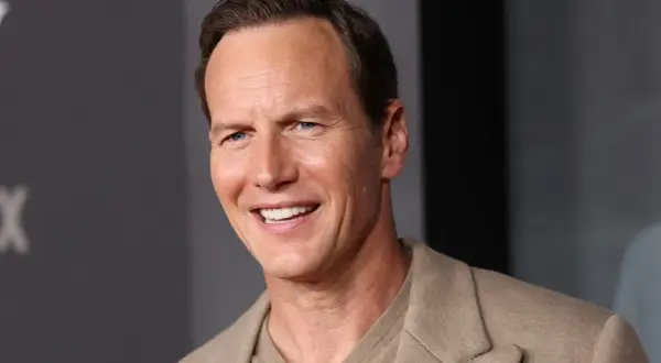 Uśmiechnięty Patrick Wilson, znany z wielu filmów, w beżowej marynarce.