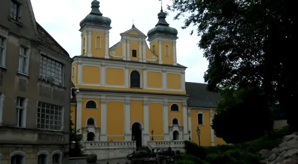 Franciszkowie Poznań wzgórze Przemysła. Żółty kościół z zielonymi kopułami góruje nad miastem.