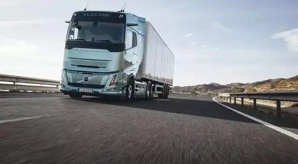 Un camion électrique Volvo roule sur une route ensoleillée, symbolisant l'autonomie et l'avenir du transport.