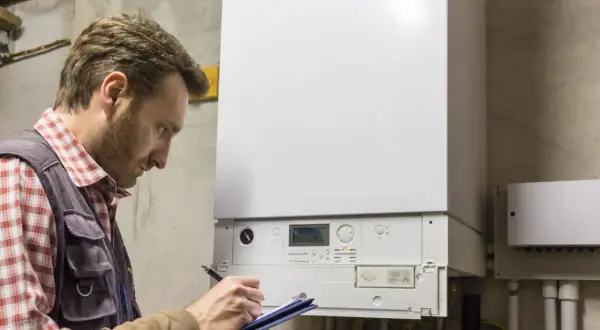 Fachowiec sprawdza instalację, by dobrać jaki piec gazowy do domu 150m2 będzie najlepszy.