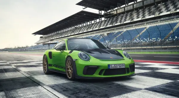Zielony Porsche 911 GT3 RS na torze wyścigowym. Sprawdź porsche 911 gt3 rs cena i specyfikację.