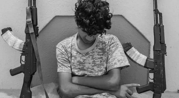 Ragazzo con fucili, uno scatto intenso di Micalizzi fotografo.