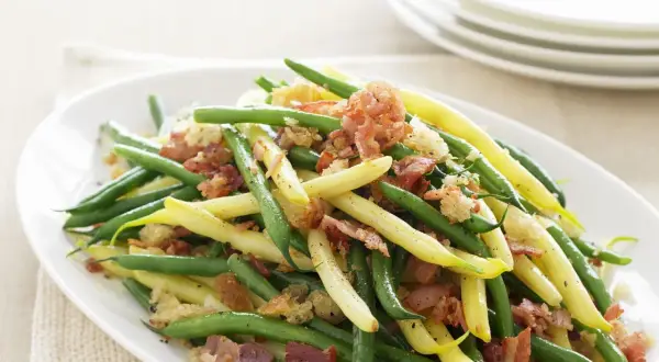 Grüne und gelbe Bohnen mit knusprigem Speck und Croutons. Ein köstliches Gericht, das zeigt, wie man Bohnen kochen kann.