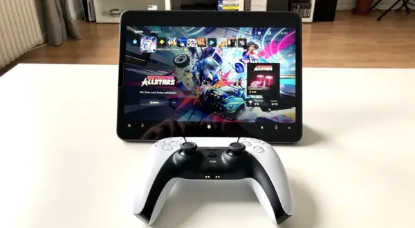 PS5 Controller mit Handy verbinden: Ein DualSense-Controller liegt vor einem Tablet, das das Spiel "Destruction AllStars" anzeigt.