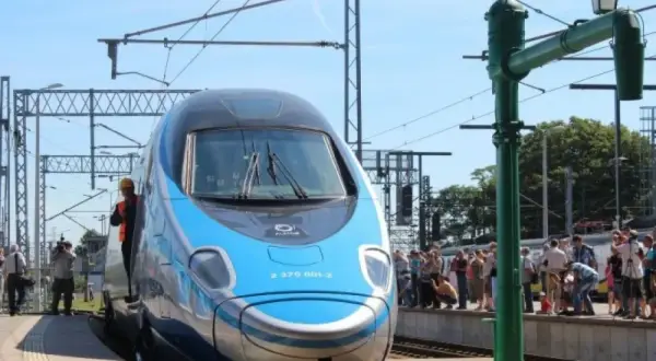 Błękitno-srebrny pociąg EIP, czy to Pendolino? Stoi na peronie, a wokół zgromadził się tłum ciekawskich.
