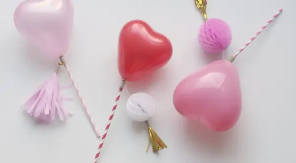 Balony w kształcie serc na patyczkach z ozdobami.