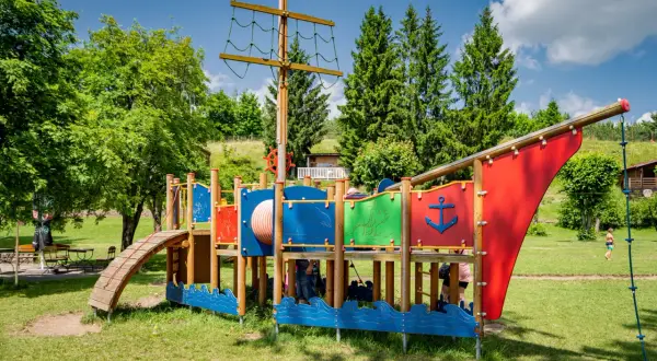 Kolorowy plac zabaw w kształcie statku pirackiego, oferujący mnóstwo atrakcji dla dzieci w Brzegu. Idealne miejsce na letnie zabawy.