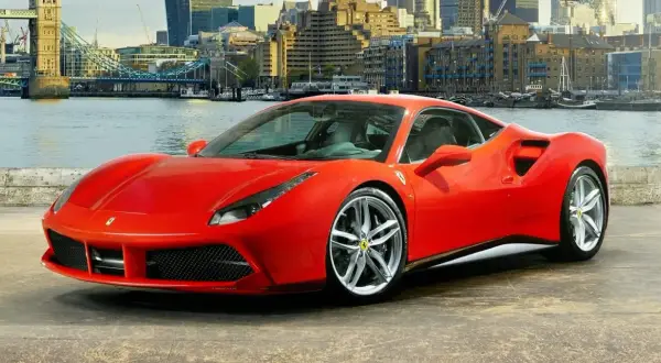 Czerwone Ferrari 488 GTB z dumą prezentuje się na tle Londynu, z Tower Bridge w tle.