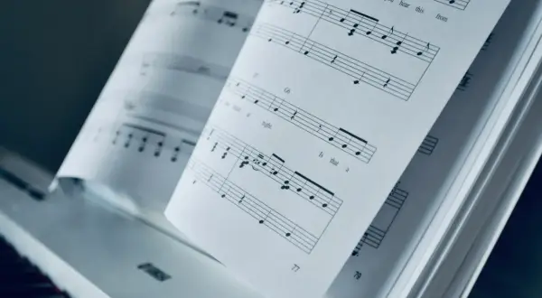 Otwarta księga nut na pianinie. Mario, czy ty wiesz, jak zagrać te nuty? PDF z muzyką czeka.