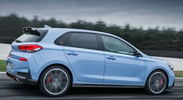Hyundai i30 N azul en movimiento, mostrando su tracción y diseño deportivo en una pista.