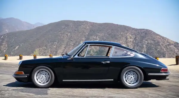 Klasyczny czarny Porsche 912 na tle górskich krajobrazów.