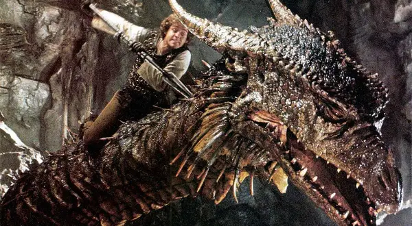 En man med svärd rider på en drake, en klassisk scen från fantasy filmer.