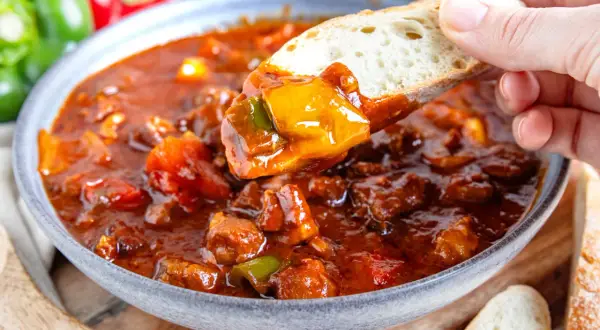 Herzhaftes Schaschliktopf Rezept: Fleischstücke und Paprika in würziger Sauce, perfekt zum Dippen mit Brot.