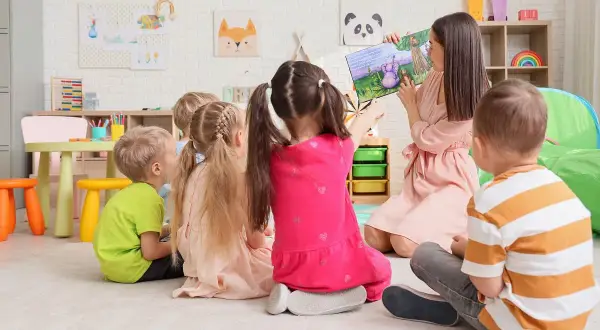 Nauczycielka czyta dzieciom bajkę. Zastanawiasz się, ile kosztuje żłobek publiczny?