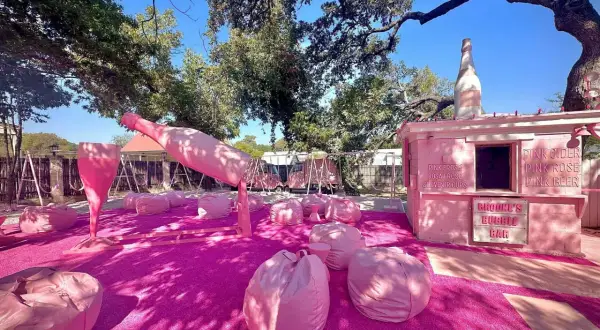 Różowa strefa relaksu z gigantyczną butelką i kieliszkiem prosecco rose, gdzie można usiąść na pufach i napić się różowego napoju.