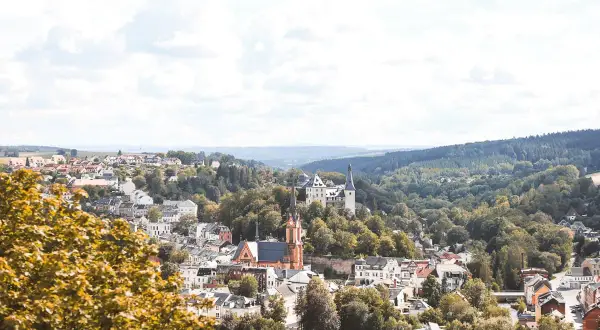 Idyllisches Städtchen mit Schloss und Kirche, umgeben von grünen Hügeln. Perfekt für Ausflugsziele Sachsen.