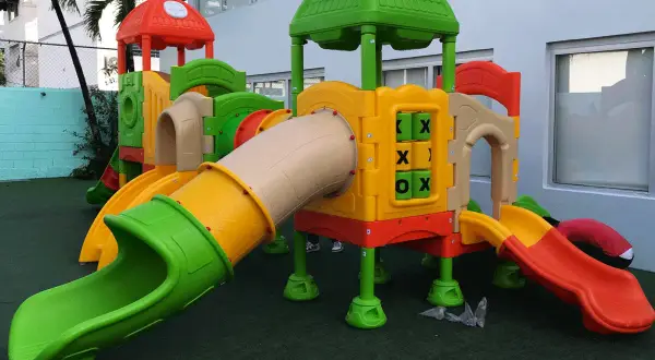 Kolorowy plac zabaw z rurami, zjeżdżalniami i grą kółko-krzyżyk.