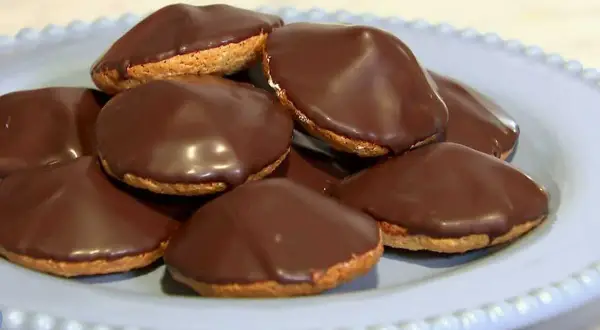 En hög med chokladöverdragna biskvier på en ljusblå tallrik. Perfekt för ett enkelt biskvier recept.
