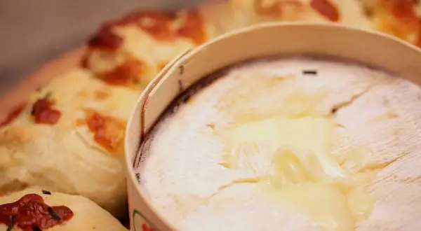Un Mont d'Or fondant, prêt à être dégusté avec du pain croustillant. Parfait pour un repas convivial.