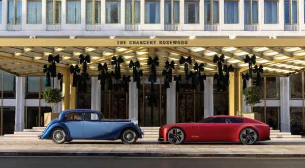 En blå klassisk brittisk sportbil ss bredvid en röd modern sportbil framför The Chancery Rosewood.