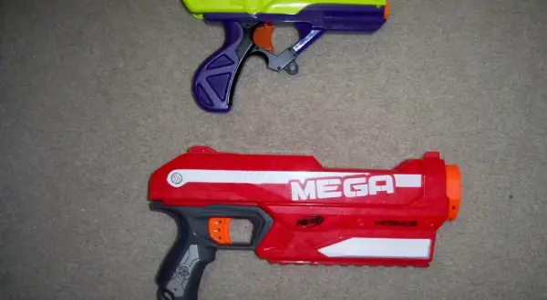 Dwa pistolety Nerf: żółto-fioletowy i czerwony Nerf Magnus.