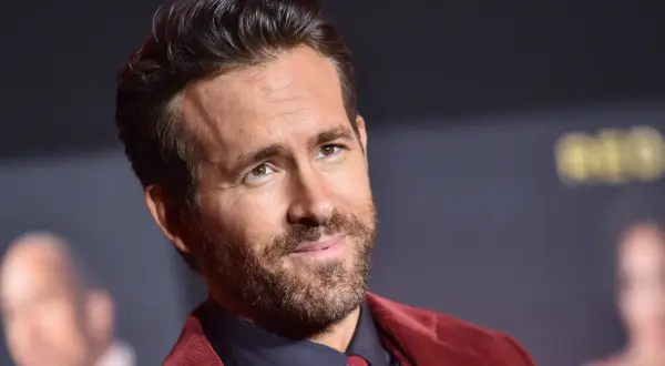 Ryan Reynolds, gwiazda wielu komediowych **filmów**, w bordowym garniturze.