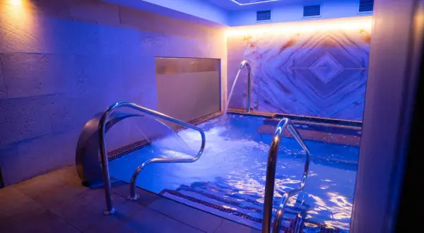 Relájate en este circuito spa con cascadas de agua y luces azules.