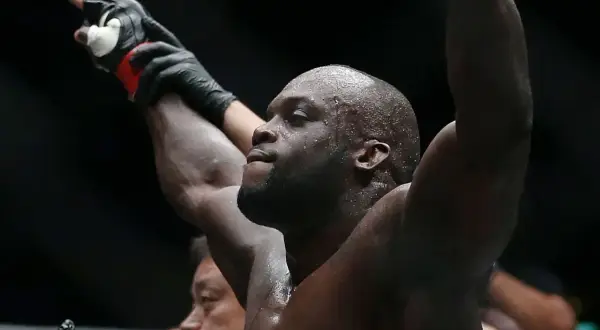Melvin Manhoef, svettig och med armarna i luften, firar en seger.
