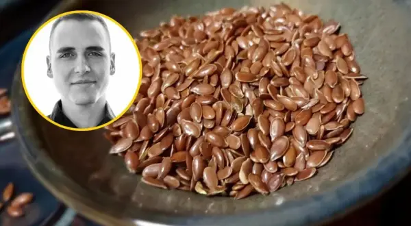 Mężczyzna z uśmiechem obok miseczki pełnej siemienia lnianego. Czy siemię lniane obniża cholesterol? Dowiedz się więcej!