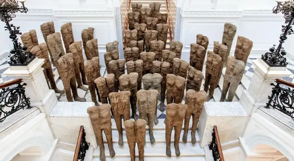 Tłum postaci ludzkich, dzieło Magdaleny Abakanowicz, schodzi po schodach.