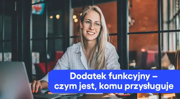 Uśmiechnięta blondynka w okularach przy laptopie. Tekst: Dodatek funkcyjny – czym jest, komu przysługuje.