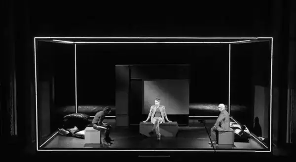 Trzech mężczyzn na scenie, w minimalistycznej scenografii. Spektakl "Ludzie inteligentni" wciąga widza w refleksję nad ludzką naturą.
