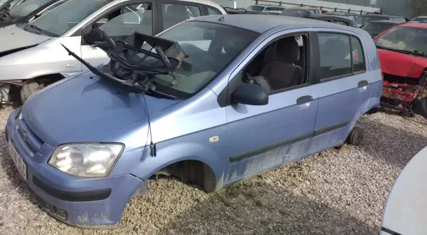 Desguace de un Hyundai Getz 1.1. El coche está en un desguace, sin ruedas y con partes rotas, evidenciando sus problemas.