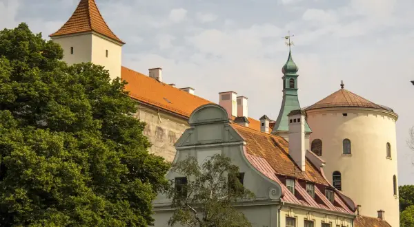 Historyczne budynki, w tym wieża i okrągła baszta, tworzą malowniczy krajobraz. Wśród nich znajduje się dom bractwa czarnogłowych.