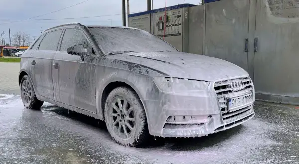 Szary Audi w pianie, gotowy do mycia samochodu na samoobsługowej myjni.