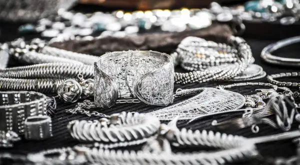 Mnóstwo biżuterii z drutu, bransoletki i naszyjniki, tworzące wrażenie kilograma srebra.