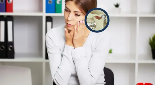 Donna con dolore alla mandibola, immagine anatomica dell'articolazione temporo-mandibolare. Un gnatologo cosa fa? Aiuta a risolvere questi problemi.