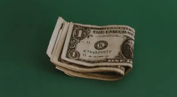 Kilka banknotów jednodolarowych leży na zielonym tle. Zastanawiasz się, jaki napiwek w restauracji zostawić?