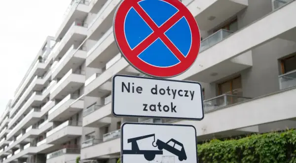 Znak zakazu zatrzymywania (B-36) z tabliczką "Nie dotyczy zatok" i piktogramem lawety odholowującej auto.