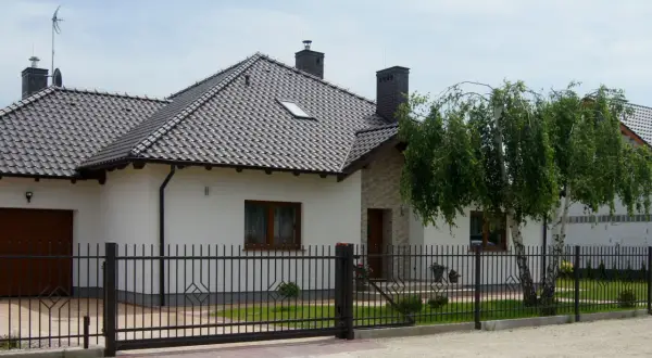 Nowy, nowoczesny dom z czarnym, metalowym ogrodzeniem. Czy to ogrodzenie bez pozwolenia?