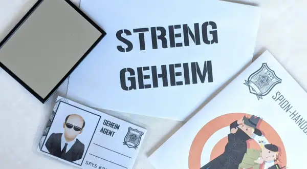 Spannende Detektiv Geburtstag Ideen: Ein Spiegel, ein Ausweis als "Geheim Agent" und eine Broschüre mit dem Titel "Spion-Handbuch" versprechen einen geheimen Missionstag.
