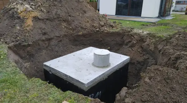 Zbiornik na deszczówkę w wykopie, przygotowywany do zakopania. Ekologiczne rozwiązanie dla domu.