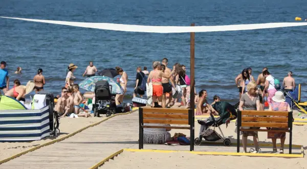 Plaża w Gdańsku tętni życiem. Ludzie kąpią się, opalają i spacerują. To idealne miejsce na relaks i odkrywanie gdańskich atrakcji dla dorosłych.
