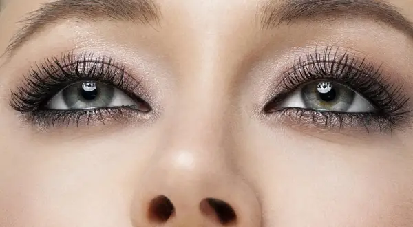 Oczy z perfekcyjnym makijażem smokey eye, długimi rzęsami i subtelnym połyskiem na powiekach.