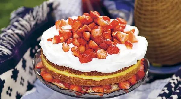 En härlig jordgubbstårta med fluffig grädde och en syrlig lemoncurdfyllning, dekorerad med färska jordgubbar. Perfekt för sommaren!