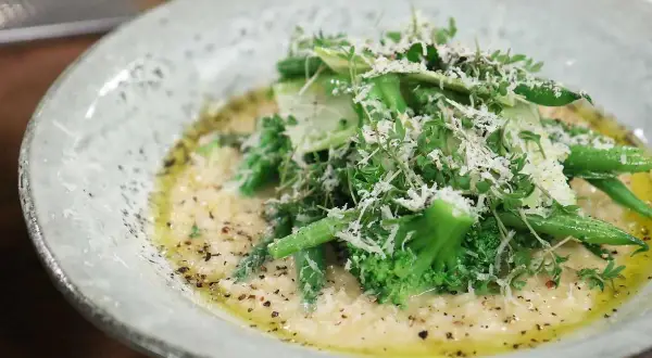 Krämig risotto med grönsaker, toppad med parmesan och färska örter. Ett perfekt risotto recept för en lätt lunch.