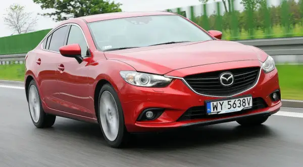 Czerwona Mazda 6 2.0 benzyna w ruchu drogowym.